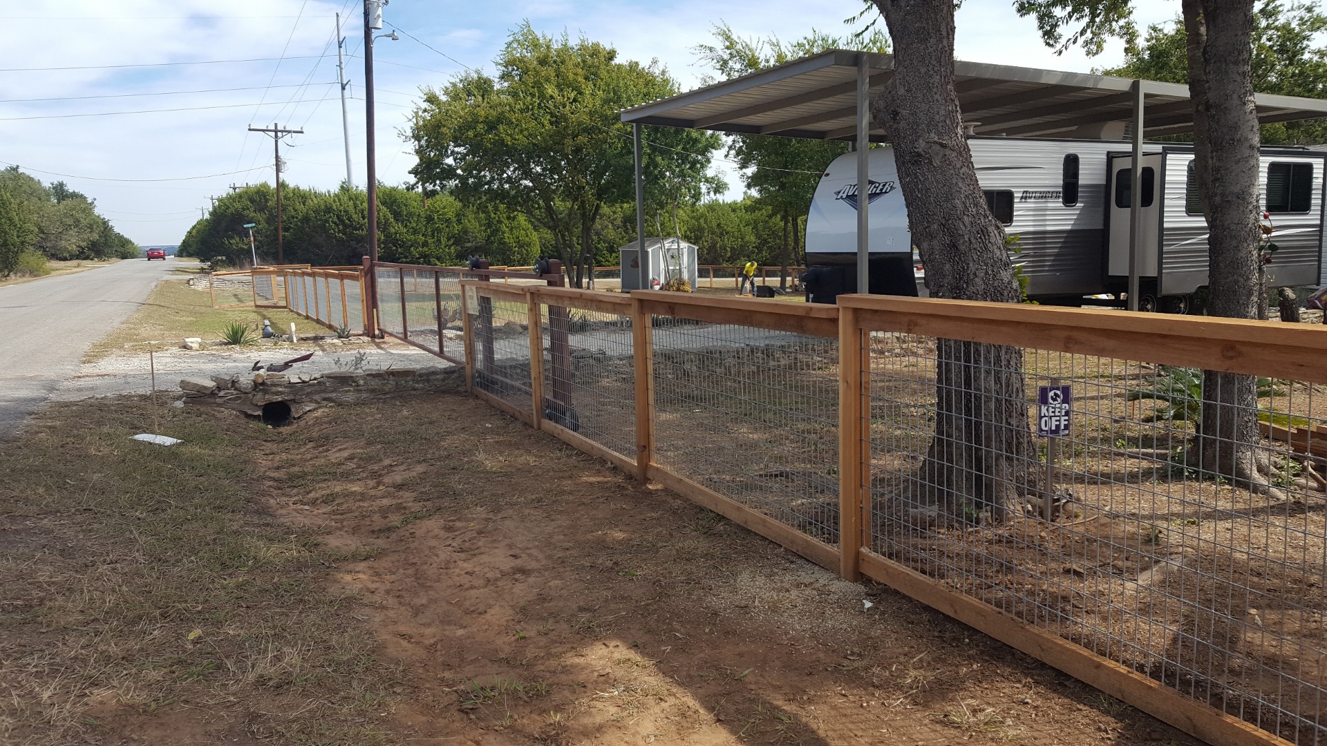 Wood-post and wire farm fence enclosing a rural Hood County property