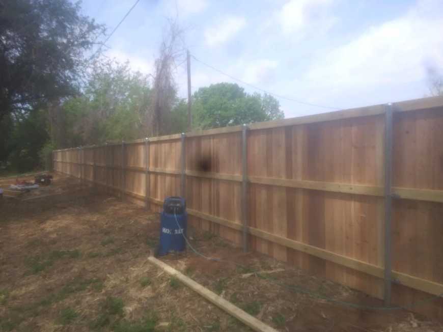 Freshly built cedar privacy fence on a Granbury-area property nearing the end of installation