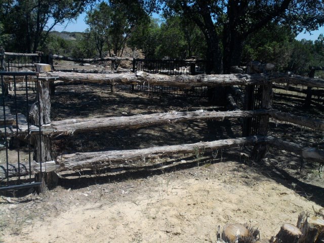 Wood-rail livestock fence enclosing a shaded pasture corral on a Granbury, TX area ranch